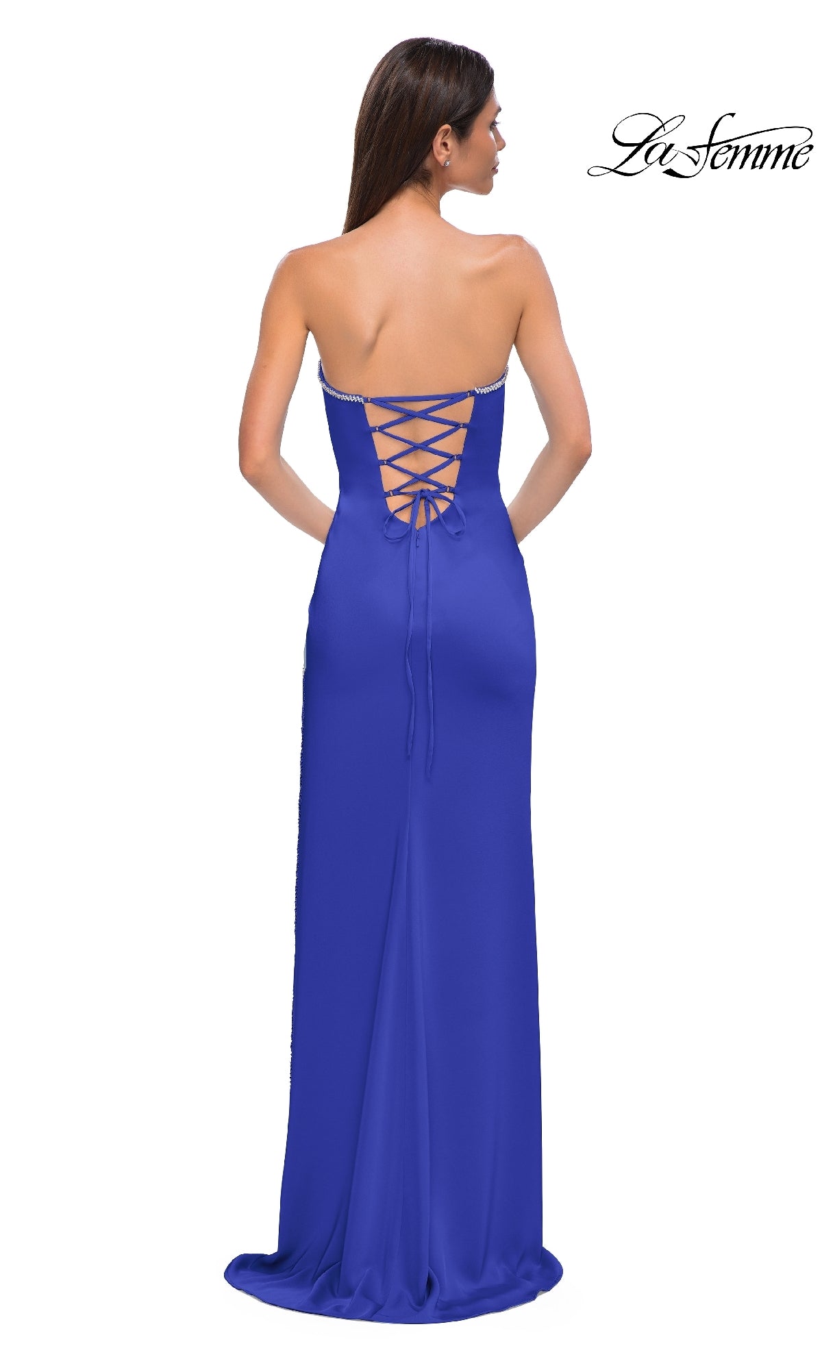 A woman stands with her back to the camera in the Classic Strapless Long Prom Dress: La Femme 32799, a royal blue lace-up gown exuding elegance. The La Femme logo is visible in the top right corner.